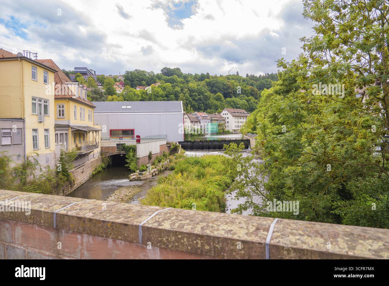 Flusslandschaft mit Brücke und umliegende Natur unter bewölktem Himmel, Kleinstadt Perle Calw, Schwarzwald, Deutschland Stockfoto