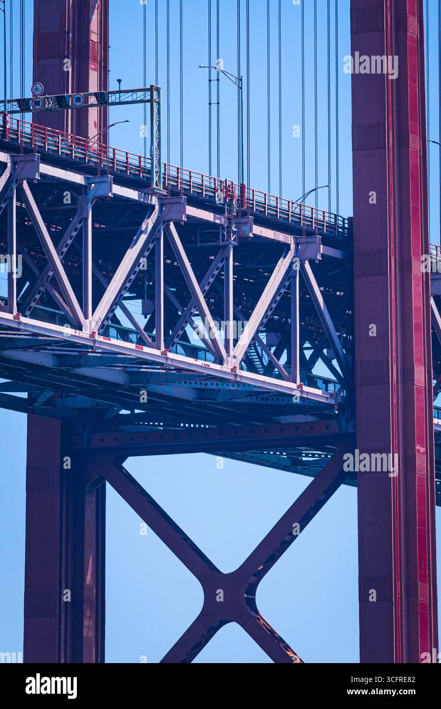 Das Bild zeigt eine Nahansicht einer roten Brückenstruktur vor einem klaren blauen Himmel. Stockfoto