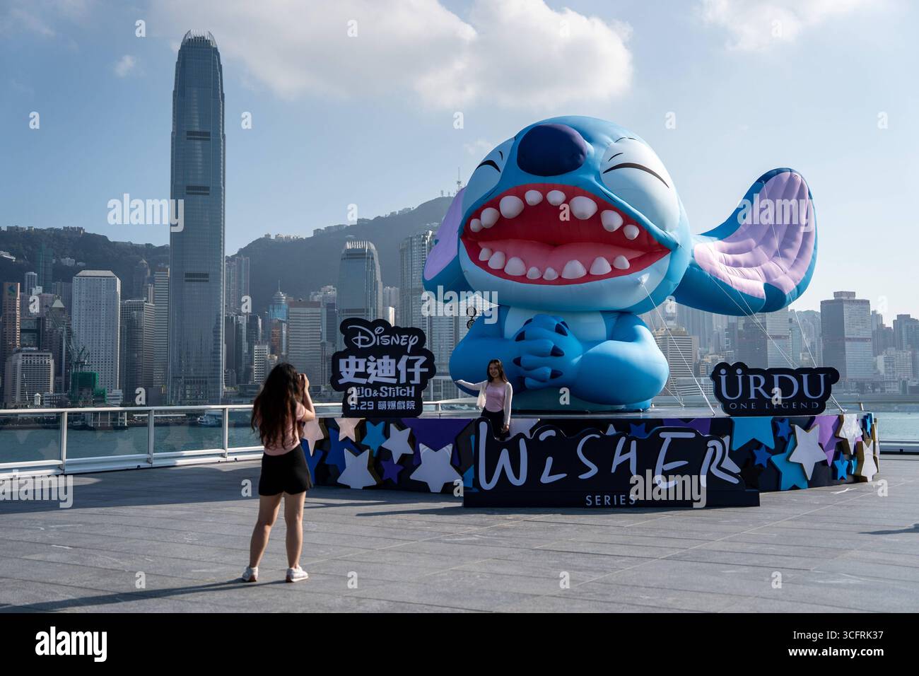 Hong Kong Daily Life Menschen posieren für Fotos mit einem größeren aufblasbaren Stich bei einer Promotion für den Lio and Stitch Move von Disney am 6. Juni 2025 in Hongkong. Stockfoto