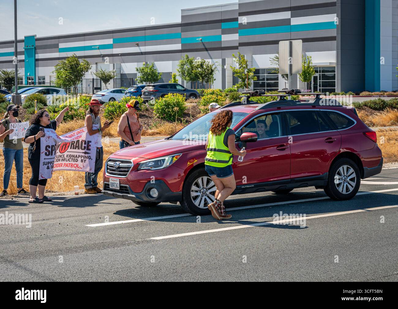 Ein Aufseher nähert sich einem Auto mit Demonstranten in der Nähe eines von der Zoll- und Grenzkontrolle (CBP) gesponserten Spartan Race-Events, bei dem ICE rekrutiert wird. Stockfoto Ein Aufseher nähert sich einem Auto mit Demonstranten in der Nähe eines von der Zoll- und Grenzkontrolle (CBP) gesponserten Spartan Race-Events, bei dem ICE rekrutiert wird. Stockfoto