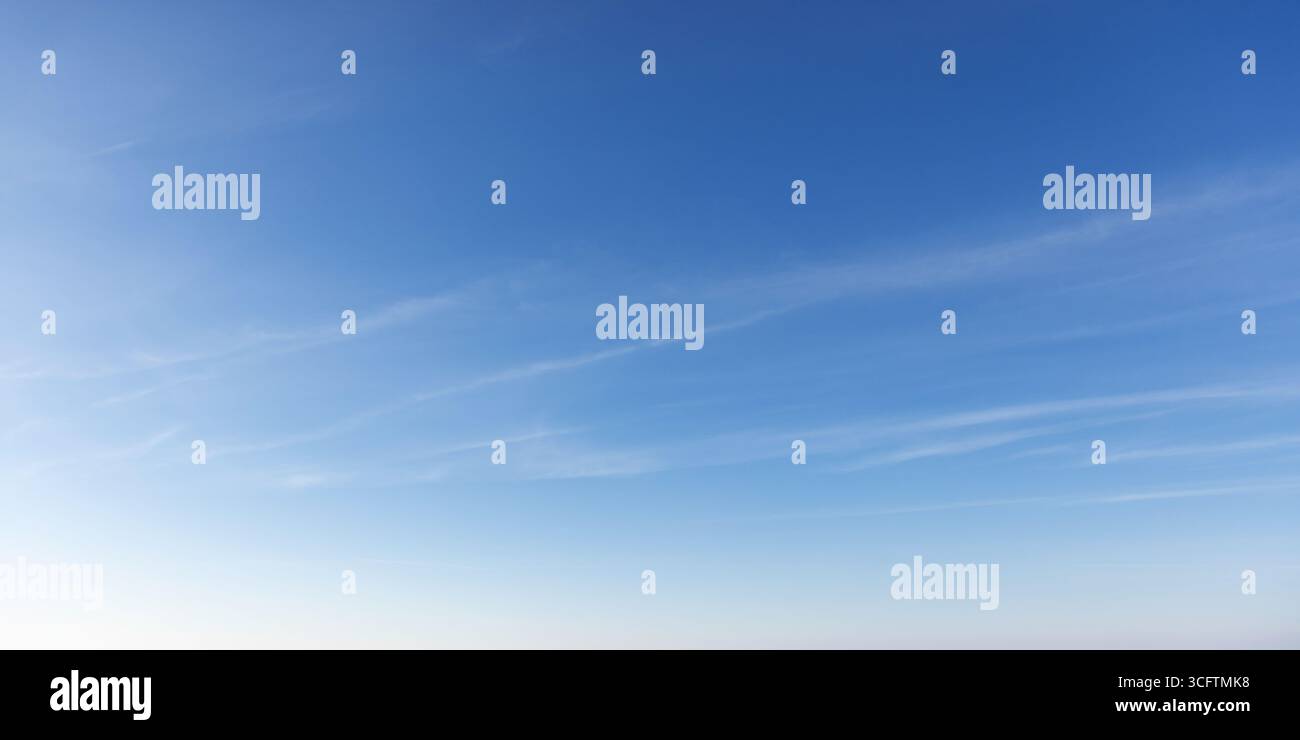 Klarer, früherer Himmel mit einem beruhigenden Farbverlauf aus Blautönen und schimmernden Wolken, der ein Gefühl von Ruhe, Freiheit und Gelassenheit weckt. Ideal als saubere Rückseite Stockfoto