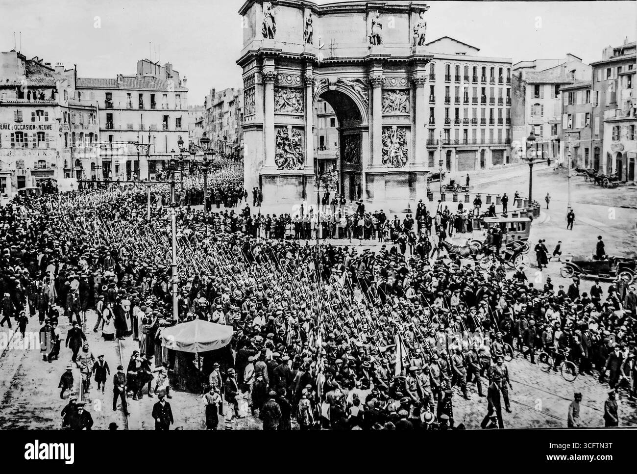 Foto aus L’Illustration (1916), das die Parade der ersten russischen Bataillone durch Marseille während des Ersten Weltkriegs zeigt. Sie marschierten am Arc de Triomphe am Place d’Aix vorbei und wurden von großen Menschenmengen begrüßt, was die französisch-russische Solidarität bei den alliierten Kriegsanstrengungen symbolisierte. Dieses Bild spiegelt sowohl die internationale Tragweite des Konflikts als auch die feierliche Begrüßung russischer Soldaten wider, die während des Ersten Weltkriegs nach Frankreich kamen. Stockfoto