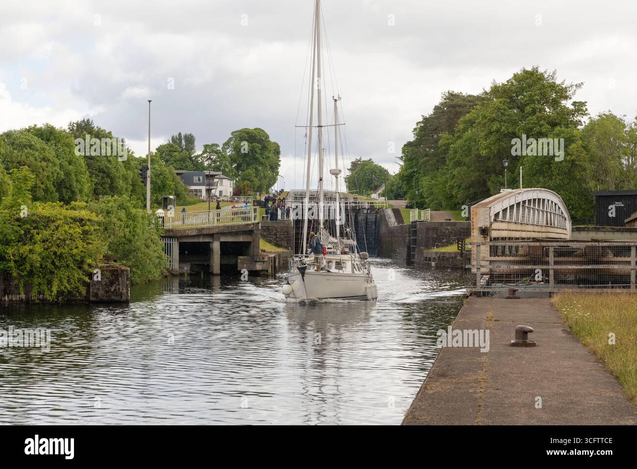 Ein Segelboot, das durch die Banavie Swing Bridge fährt, während es den Caledonian Canal am Fuße der Neptuntreppe in der Nähe von Fort William verlässt Stockfoto