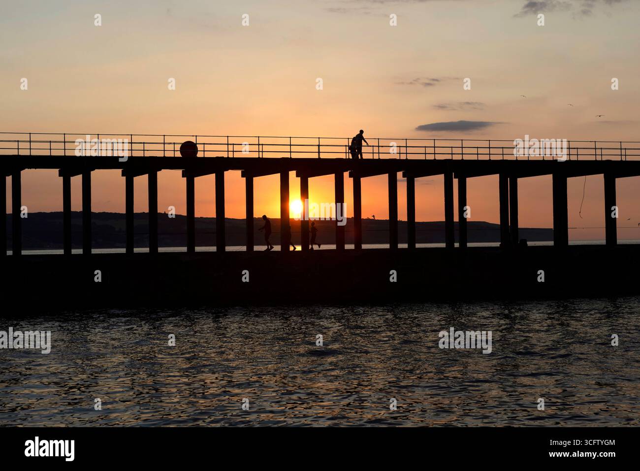 Whitby Pier bei Sonnenuntergang an einem Sommerabend Stockfoto