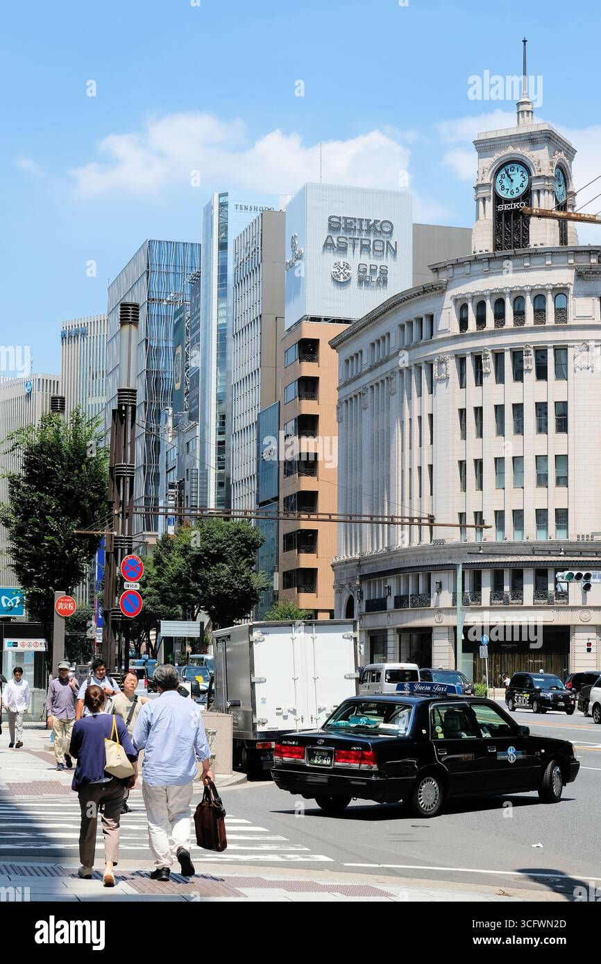 Seiko Uhrenturm im WAKO-Gebäude auf Chuo-dori mit Autos und Fußgängern in Ginza, Tokio, Japan; Grand Seiko, Seiko Astron, Seiko House. Stockfoto