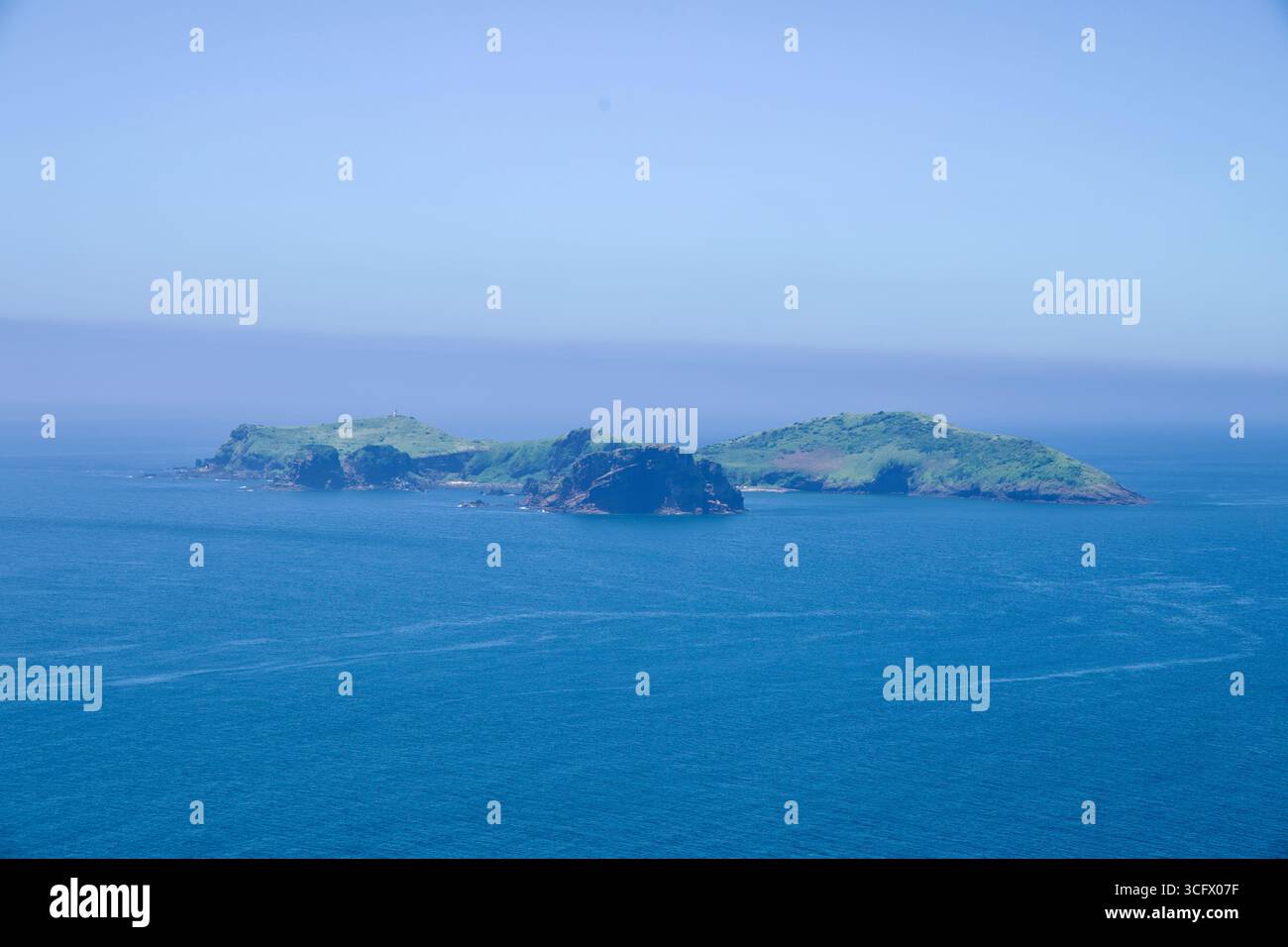 Chagwido Island ist eine Inselgruppe, die vor der Küste des Suwolbong Peak zu sehen ist, mit ihren grasbewachsenen Spitzen und dunklen Klippen, die aus tiefblauem Wasser entlang des Westens von Jeju ragen Stockfoto