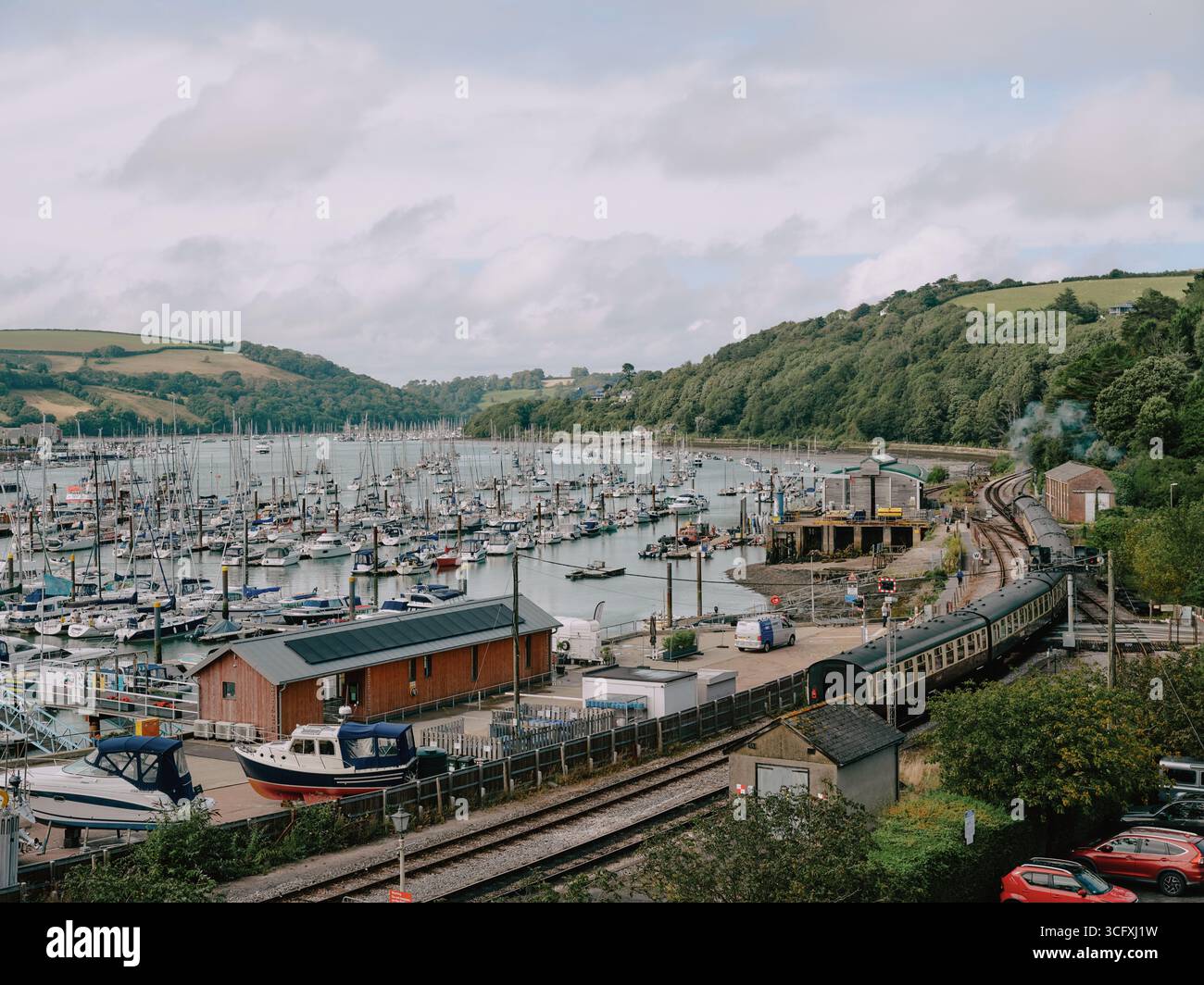Der Yachthafen, die angelegten Boote und die Dampfeisenbahn verlassen Kingswear in Dartmouth Harbour, Kingswear, Dartmouth Devon England, Großbritannien Stockfoto
