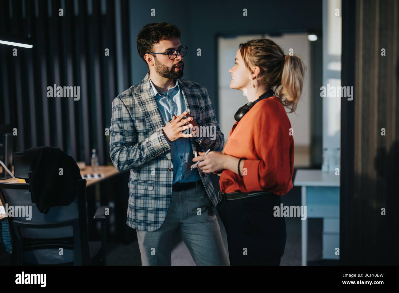 Kollegen diskutieren über die Arbeit in modernen Büroumgebungen Stockfoto