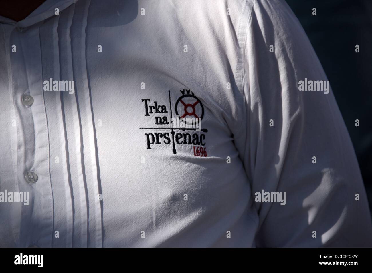 Pula, Kroatien. August 2025. Ein Mann trägt ein Hemd mit dem Logo Trka na prstenac (Rennen zum Ring) Wettbewerb in der Stadt Barban, Kroatien am 24. August 2025. Während des Rennens muss ein Reiter in nicht mehr als 12 Sekunden eine 150 Meter lange Strecke zurücklegen und den Prstenac (ähnlich dem Sinj alka) treffen. Foto: SASA Miljevic/PIXSELL Credit: Pixsell/Alamy Live News Stockfoto