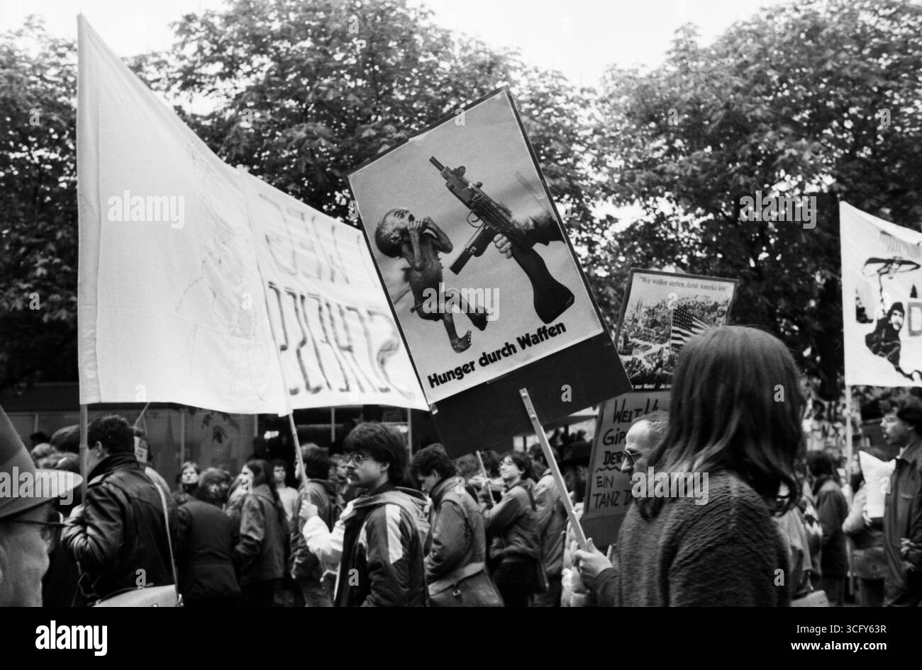 Protestaktion während der Demonstrationen gegen den Weltwirtschaftsgipfel im Mai 1985 in Bonn. Teilnehmer zeigen kritische Plakate mit politischen und satirischen Botschaften zu Rüstung, Hunger und Regierung. Stockfoto