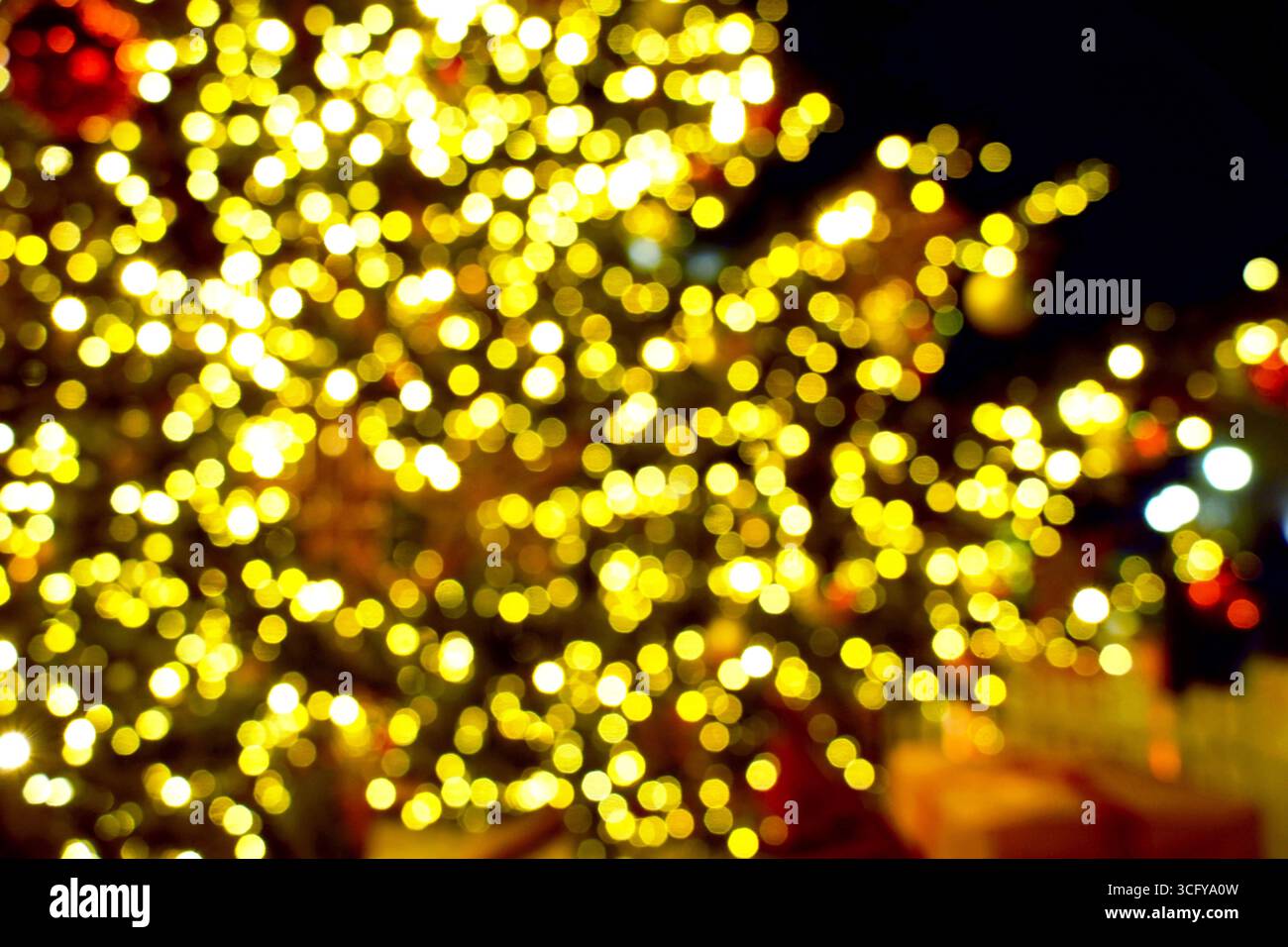 Goldene Lichter schaffen eine gemütliche, intime Atmosphäre. Verschwommener Hintergrund mit festlicher Beleuchtung, der ein Gefühl von Komfort, friedlichen Momenten und saisonaler Wärme weckt Stockfoto