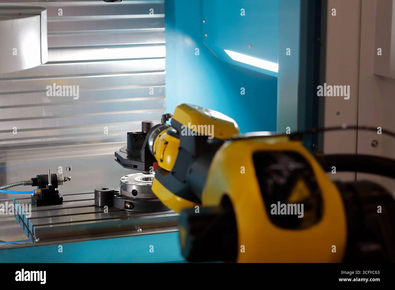 CNC-Maschinenautomatisierung mit Roboterarm. Automatisierung des Ladens von Teilen in CNC-Maschinen mit industriellem Roboterarm-Manipulator. Selektiver Fokus. Stockfoto