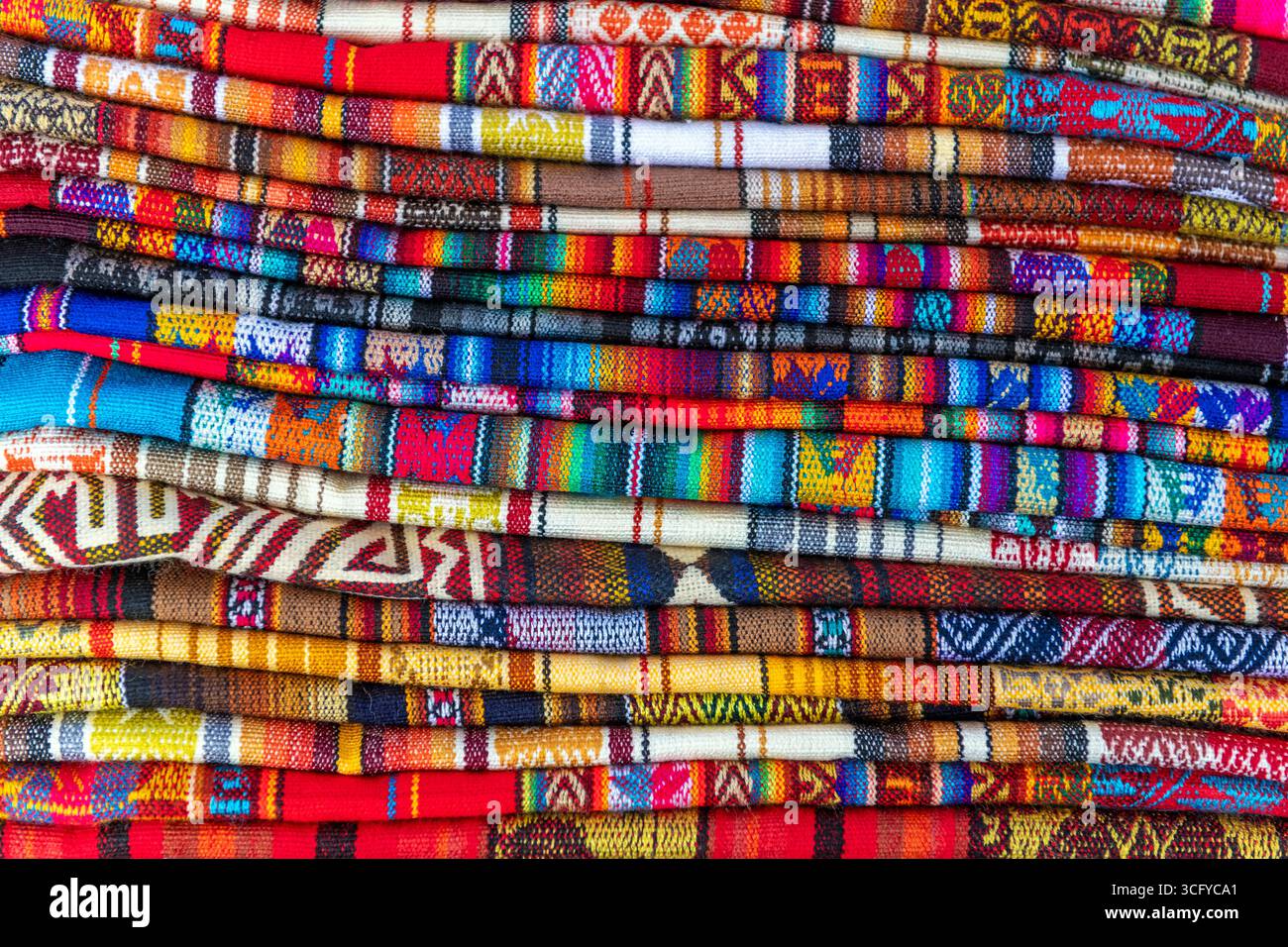 Traditionelle Textilien und Stoffe aus den Anden auf dem Kunst- und Handwerksmarkt in Otavalo, Ecuador. Stockfoto