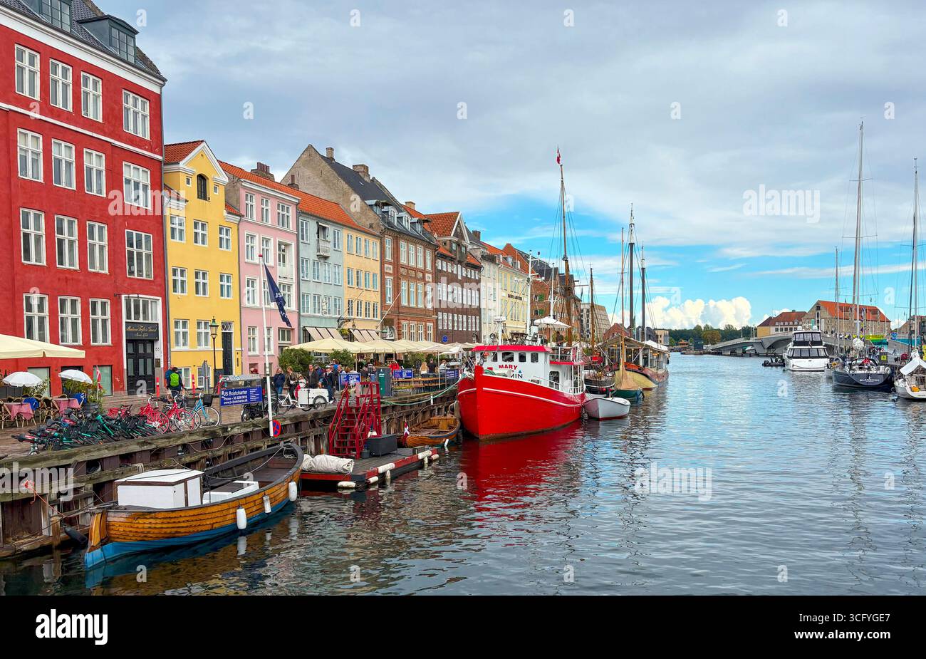 Nyhavan, Kopenhagen, Dänemark - 2. August 2025: Bezaubernder Kanal gesäumt von lebhaften Gebäuden, Booten und Sitzplätzen im Freien in Kopenhagen. Stockfoto