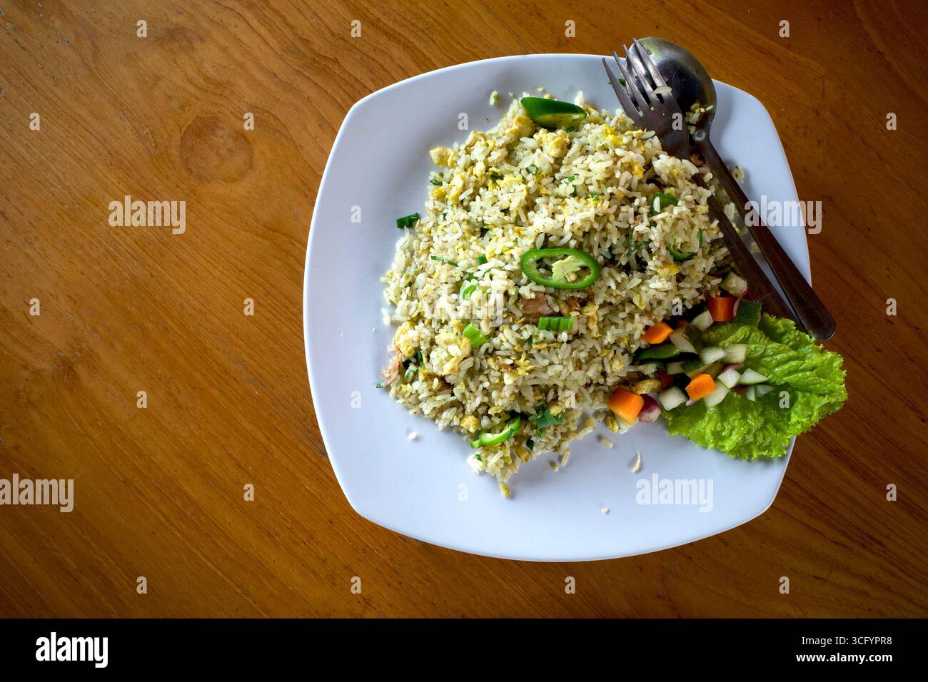 Nasi Goreng, gebratener Reis, traditionelle indonesische Küche, mit Hühnereier und Gemüse auf einem weißen Teller. Indonesische Küche. Stockfoto