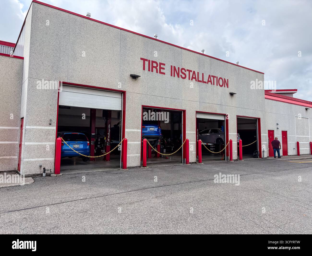 Costco Reifenmontagezentrum mit mehreren offenen Servicebereichen, in denen Fahrzeuge auf Liften gewartet werden. Außenansicht eines Einzelhandels-Kfz-Service DE Stockfoto