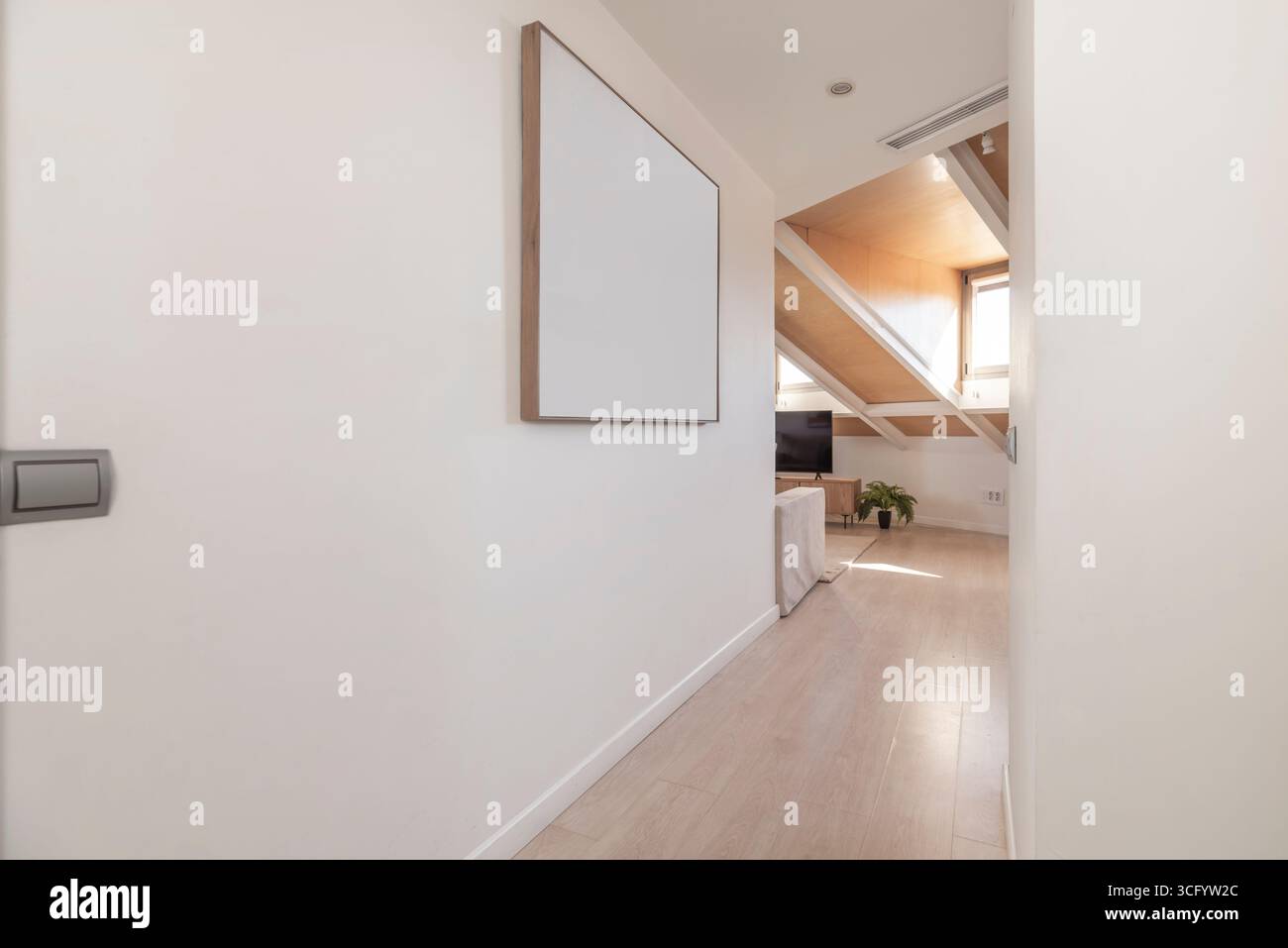 Flur mit indirekter Beleuchtung in den Sockelleisten und weiß lackierten Türen, die einen Effekt von Tiefe und Geräumigkeit schaffen Stockfoto