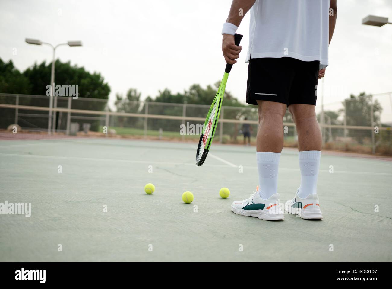 Mann, der einen Tennisschläger auf dem Platz in Riad, Saudi-Arabien hält, der Sport, Erholung und gesunden Lebensstil repräsentiert. Stockfoto