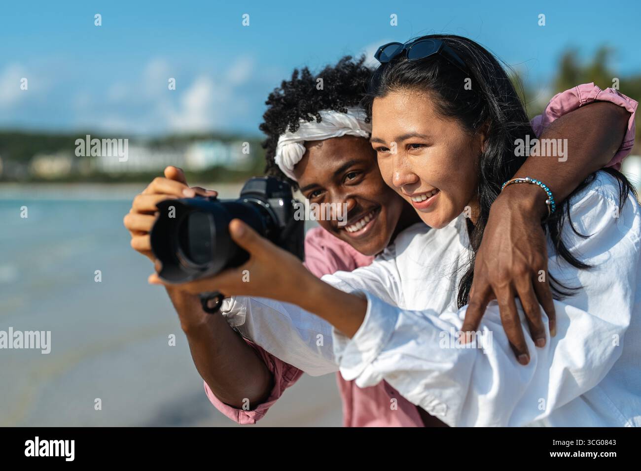 Ein junges Paar, das einen romantischen und fröhlichen Strandurlaub genießt und süße Erinnerungen und Momente der Liebe, des Glücks und der tiefen Verbundenheit in einem Tropen festhält Stockfoto