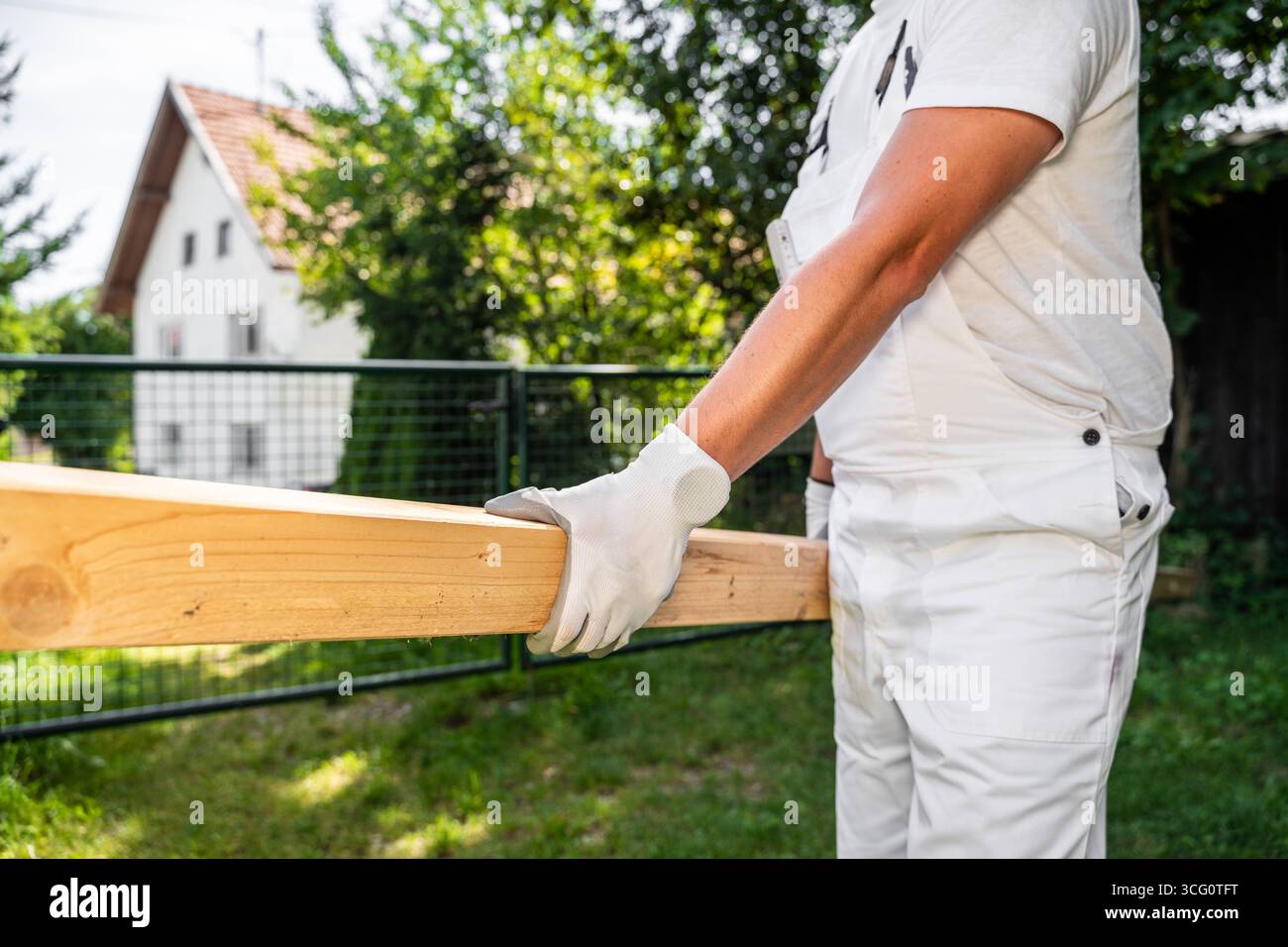 Bayern, Deutschland - 25. August 2025: Ein Zimmermann trägt einen Holzbalken auf einer Baustelle. Symbolbild der körperlichen Arbeit und der Verwendung von Holz als Naturbaustoff in der Bauindustrie *** ein Zimmermann trägt auf einer Baustelle einen Holzbalken. Symbolbild körperliche Arbeit und den Einsatz von Holz als natürlicher Baustoff im Baugewerbe Stockfoto