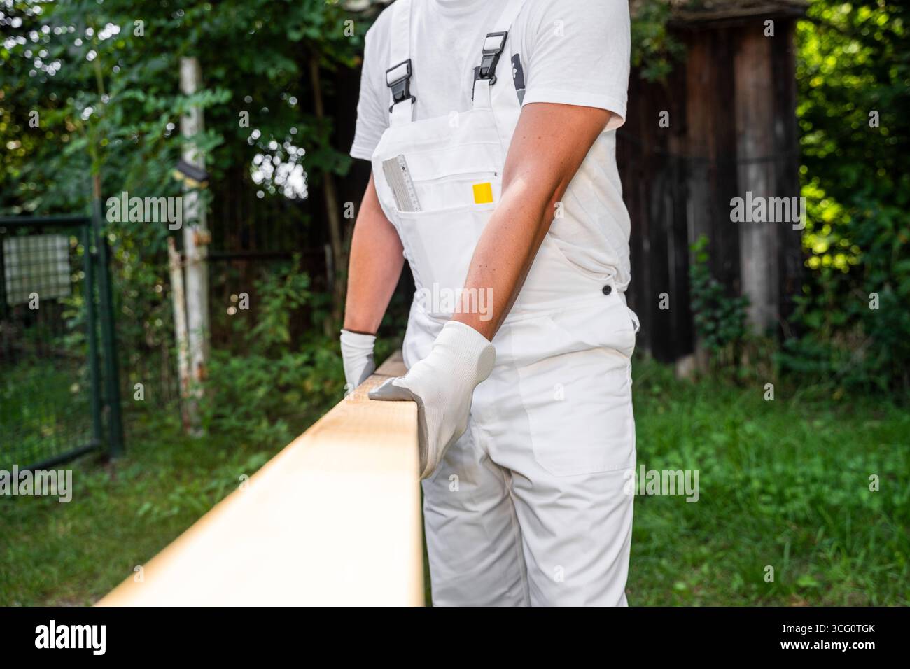 Bayern, Deutschland - 25. August 2025: Ein Zimmermann trägt einen Holzbalken auf einer Baustelle. Symbolbild der körperlichen Arbeit und der Verwendung von Holz als Naturbaustoff in der Bauindustrie *** ein Zimmermann trägt auf einer Baustelle einen Holzbalken. Symbolbild körperliche Arbeit und den Einsatz von Holz als natürlicher Baustoff im Baugewerbe Stockfoto