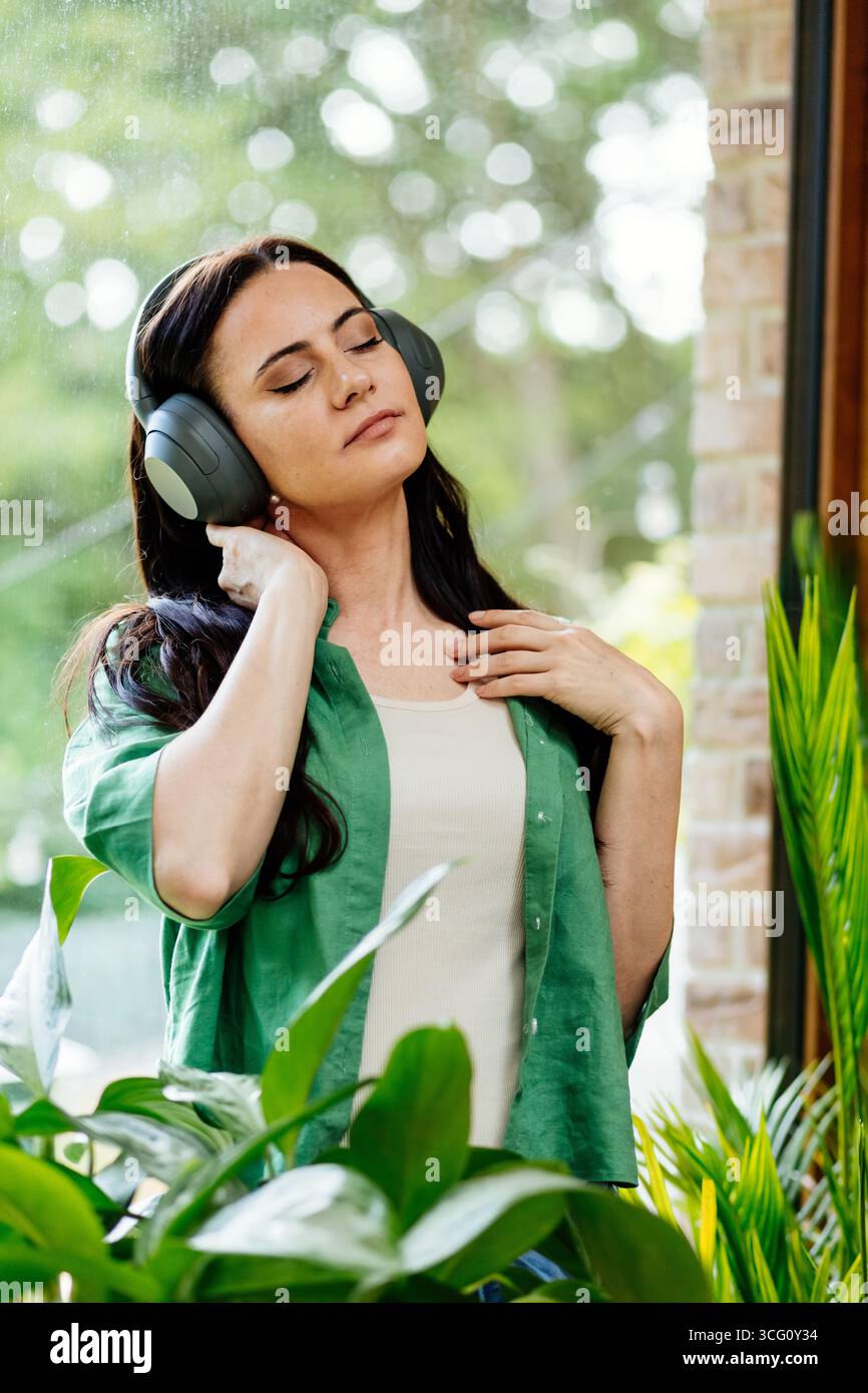 Entspannte Frau, die Freizeit genießt und Musik hört. Stockfoto