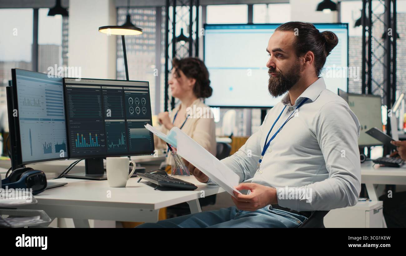 Büromitarbeiter prüfen KPI-Kennzahlen auf Monitor und Analysen auf Dateien, entwickeln eine Vision und Geschäftsstrategie, um Ziele und Erfolg zu erreichen. Eine professionelle Einstellung beibehalten. Stockfoto