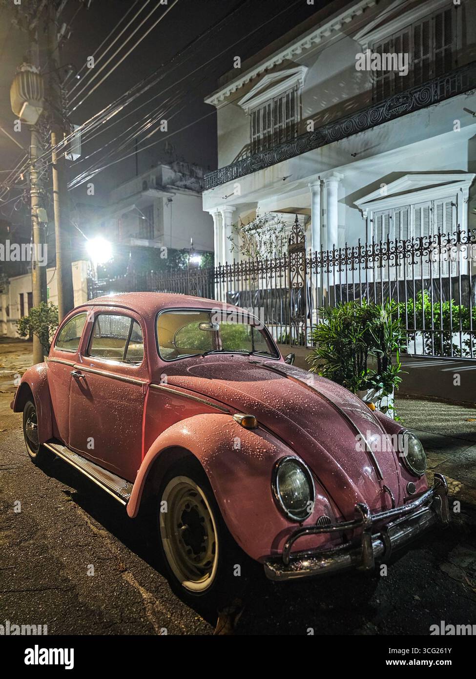 Rosafarbener Vintage Volkswagen Käfer mit Tau, der nachts in Urca, Rio de Janeiro, Brasilien geparkt hat Stockfoto
