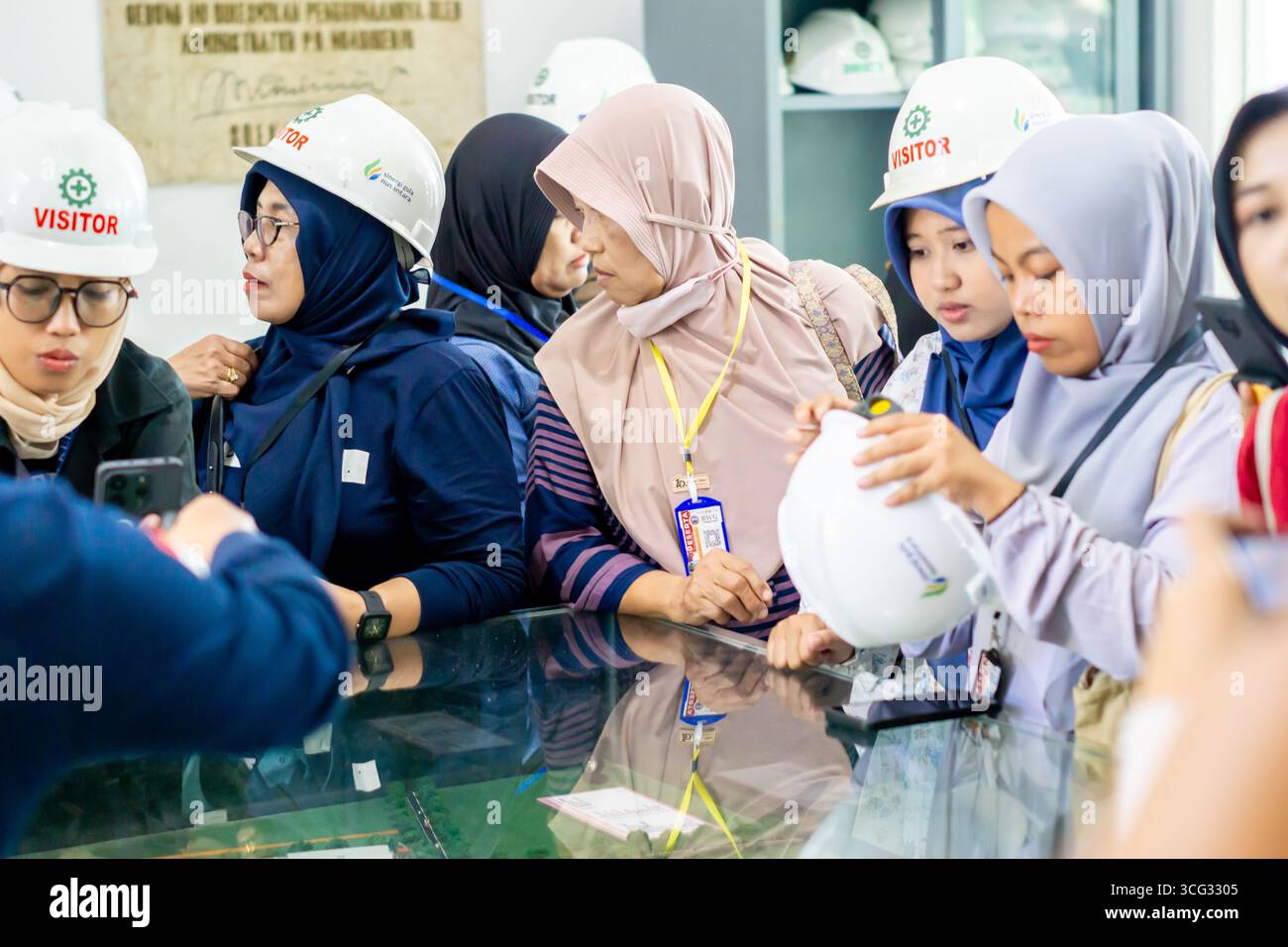 Mehrere Indonesier besuchten die Fabrik. Gruppe von Besuchern auf der Werksbesichtigung. Stockfoto