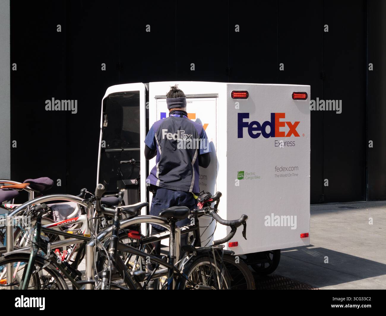 FedEx Express Pedicab-Kurier mit Lastenfahrrad für Paketzustellungen in Central London, Großbritannien. Stockfoto