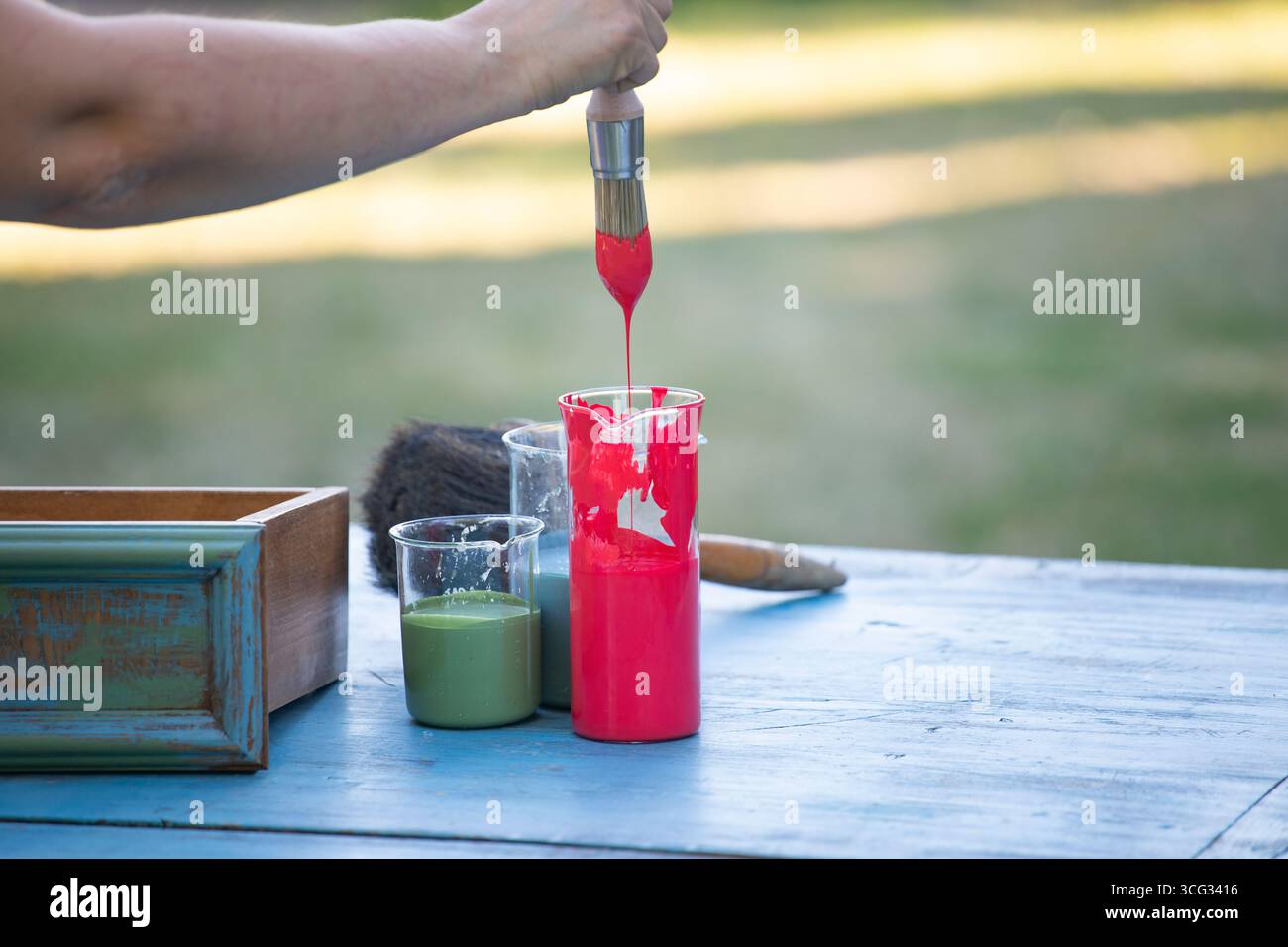 Holzmöbel mit Kreidemalerei aus menschlicher Hand. Alte Holzmöbel werden mit brandneuer, farbenfroher Kreidefarbe erneuert. Die Innendekoration wird neu gestaltet Stockfoto