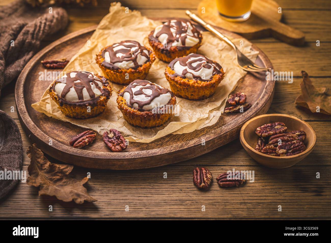 Karottenmuffings mit Nüssen, geeist mit Frischkäse und Schokolade und Karottensaft Stockfoto