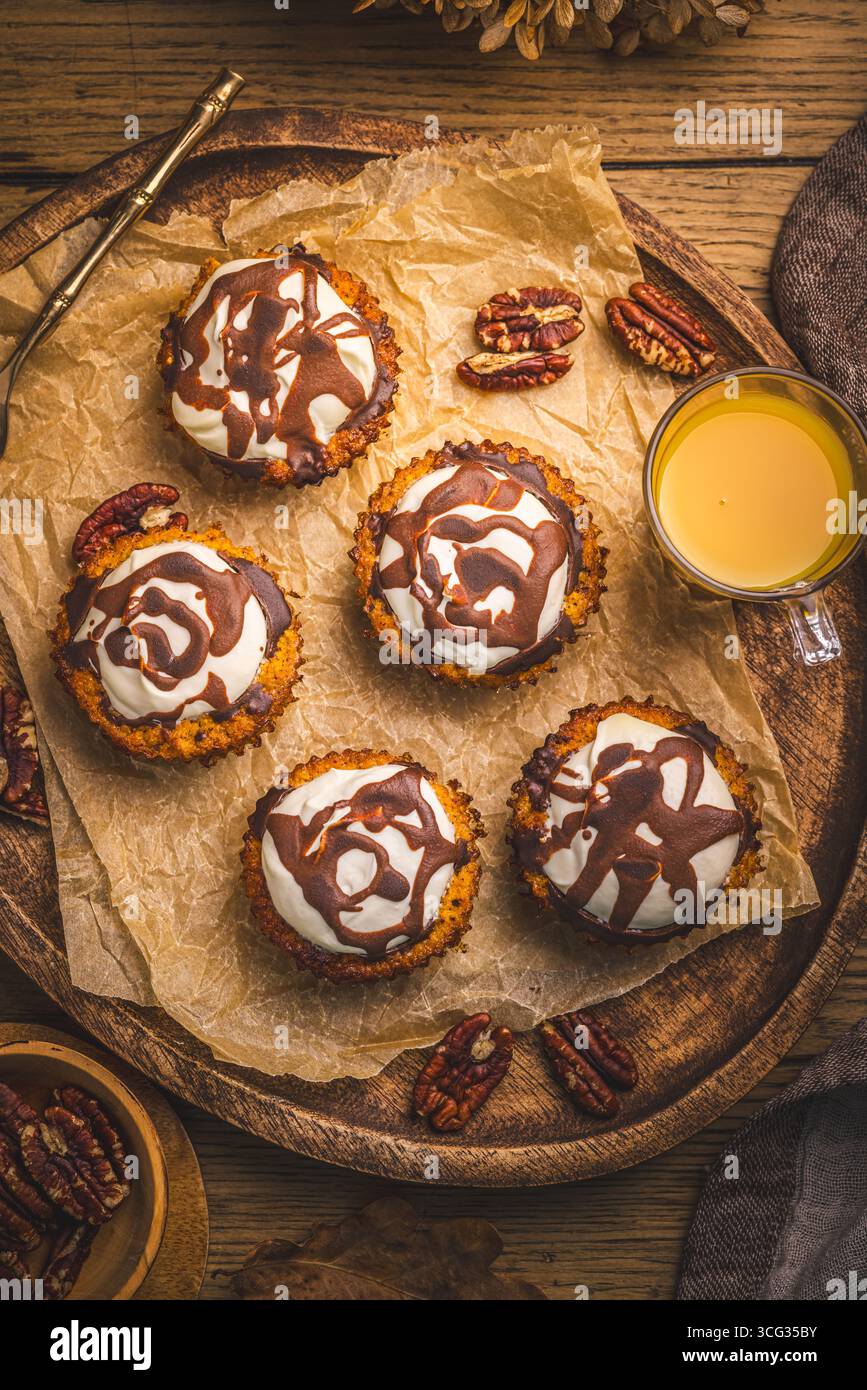 Karottenmuffings mit Nüssen, geeist mit Frischkäse und Schokolade und Karottensaft Stockfoto