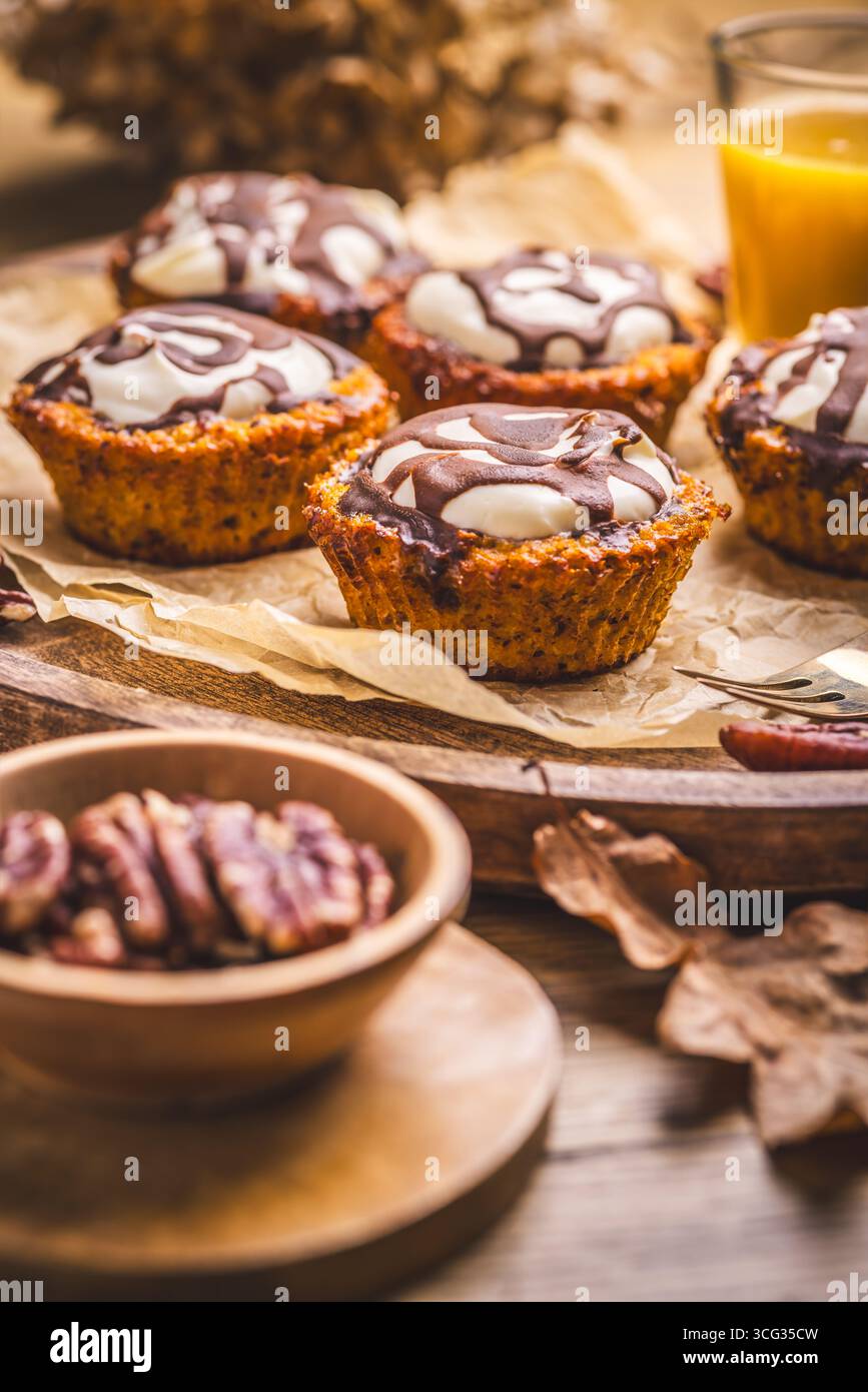 Karottenmuffings mit Nüssen, geeist mit Frischkäse und Schokolade und Karottensaft Stockfoto