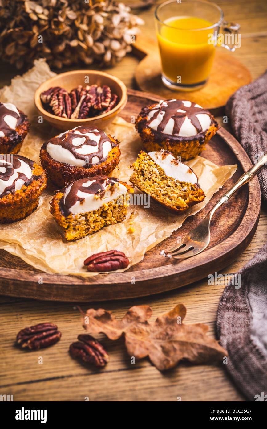 Karottenmuffings mit Nüssen, geeist mit Frischkäse und Schokolade und Karottensaft Stockfoto