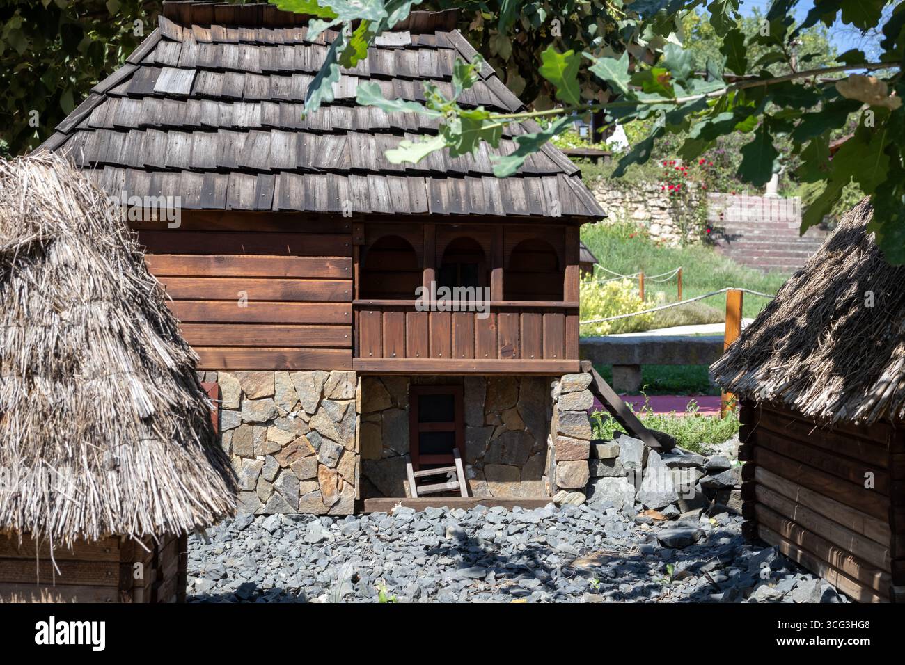 Eine bezaubernde Sammlung traditioneller Miniaturhäuser, mit einer detaillierten Holzstruktur mit einem Schindeldach und einem rustikalen Steinfuß, umgeben von B Stockfoto