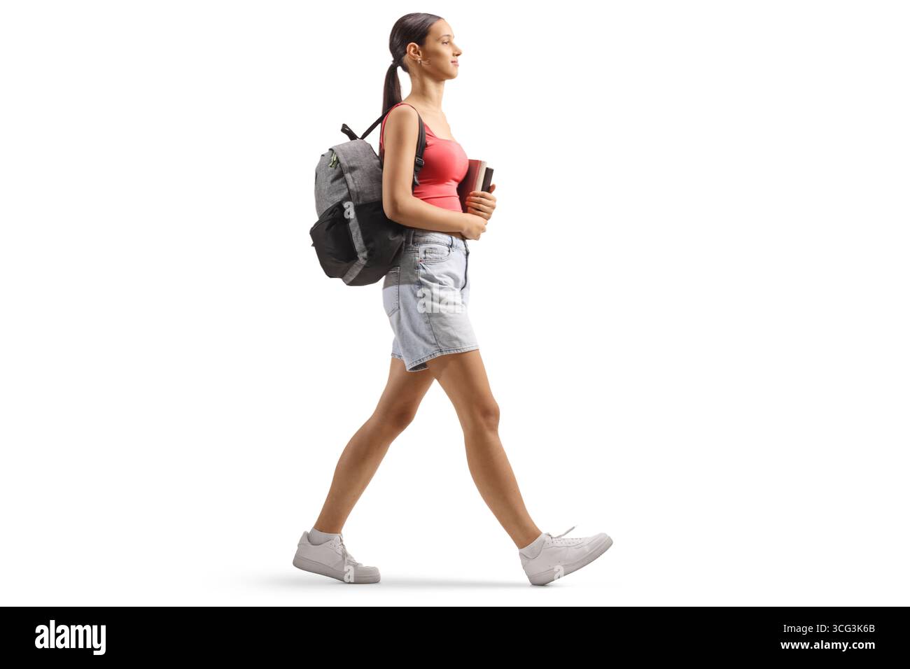 Profilaufnahme einer Schülerin im Teenageralter, die Bücher hält und isoliert auf weißem Hintergrund läuft Stockfoto