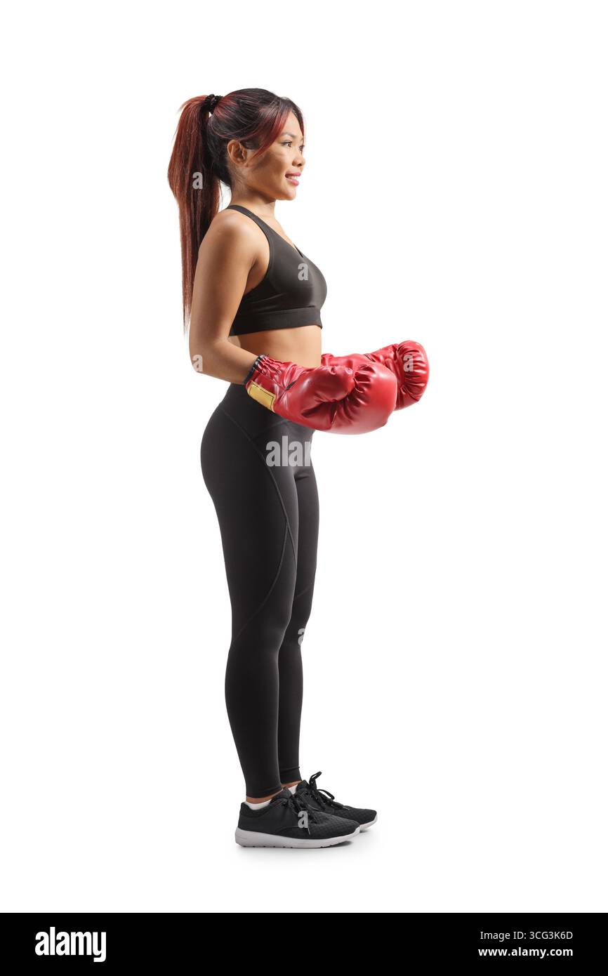 Profilaufnahme einer jungen asiatischen Frau mit roten Boxhandschuhen auf weißem Hintergrund Stockfoto