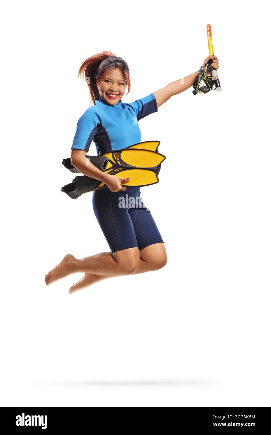 Aufgeregte Frau in einem Taucheranzug, die Tauchermaske und Flossen hält und isoliert auf weißem Hintergrund springt Stockfoto