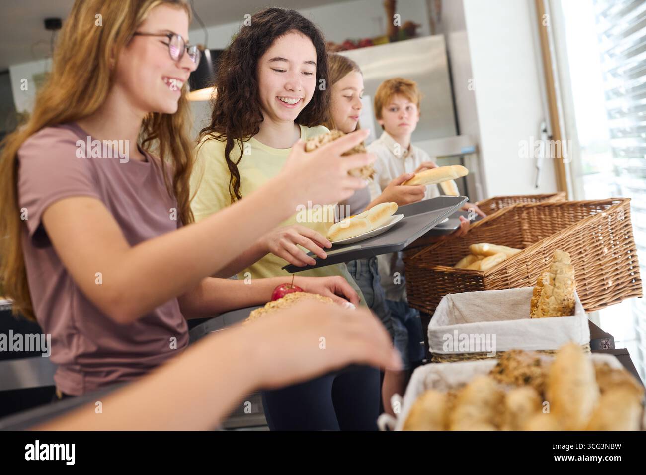 Gruppe von Schülern, die frische Backwaren in einer Cafeteria auswählen Stockfoto