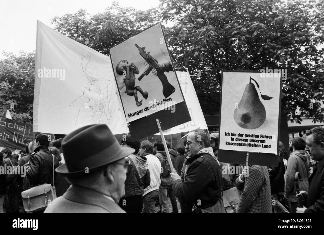 Protestaktion während der Demonstrationen gegen den Weltwirtschaftsgipfel im Mai 1985 in Bonn. Teilnehmer zeigen kritische Plakate mit politischen und satirischen Botschaften zu Rüstung, Hunger und Regierung. Stockfoto