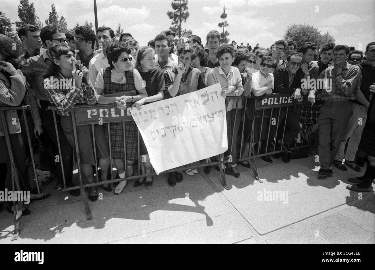 Studentinnen und Studenten protestieren beim Besuch des ehemaligen deutschen Kanzlers Konrad Adenauer an der Hebräischen Universität Jerusalem. Einige stehen mit kritischen Plakaten hinter einer Polizeibarrikade. Israel, Mai 1966. Stockfoto