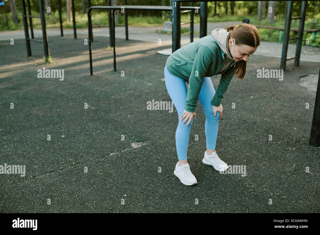 Junge kaukasische Frau, die sich nach einem Outdoor-Workout im Stadtpark ausruhen lässt Stockfoto