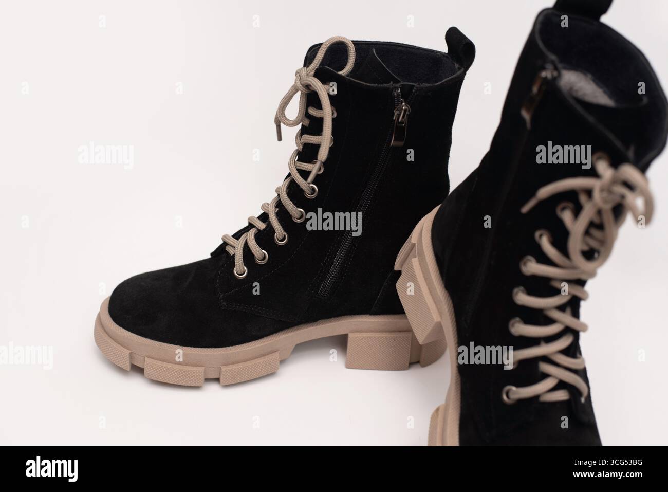 Trendige schwarze Wildlederstiefel mit beigefarbenen Sohlen und Schnürsenkeln, ideal für Modebegeisterte und Alltagsbekleidung, mit elegantem Design Stockfoto