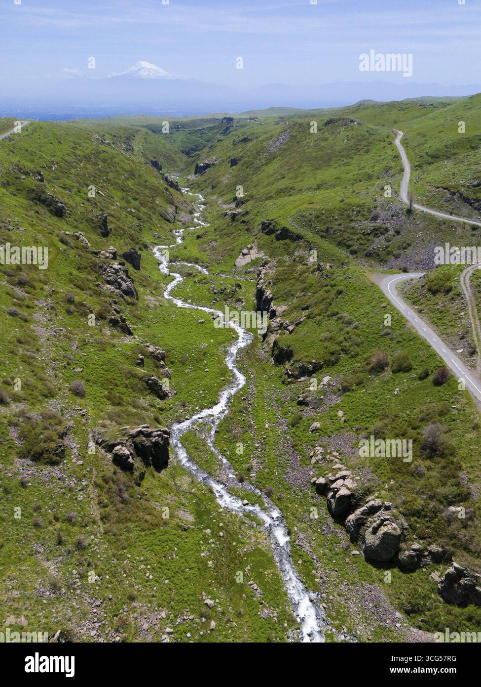 Ein Panoramablick zeigt einen Fluss, der durch eine grüne, hügelige Landschaft fließt, aus der Luft, Fluss und Schlucht Arkashian, im Hintergrund Mount Ararat in Tur Stockfoto