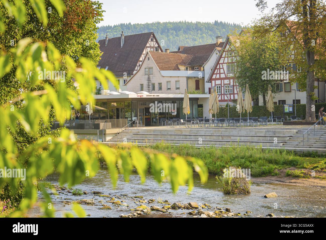 Idyllischer Blick auf Fachwerkhäuser am Fluss, umgeben von grünen Bäumen an einem Sommertag, Nagold, Stadtteil Calw, Schwarzwald, Deutschland Stockfoto