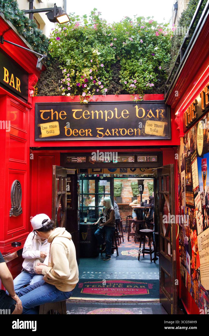 Außenansicht der Temple Bar, einem berühmten Pub in Dublin, Irland, mit seiner berühmten roten Fassade und dem Biergarten. Stockfoto