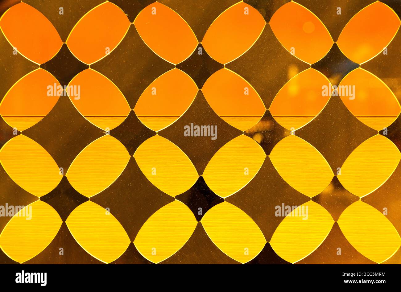 Gelbes dekoratives, durchscheinendes Glas mit Rautenmuster. Stockfoto