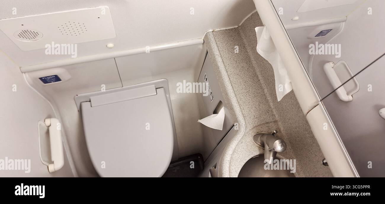 Die Anlage verfügt über eine saubere Toilette mit Toilette und einem kleinen Waschbecken, entworfen für Komfort im Zug. Der Platz wird effizient genutzt Stockfoto