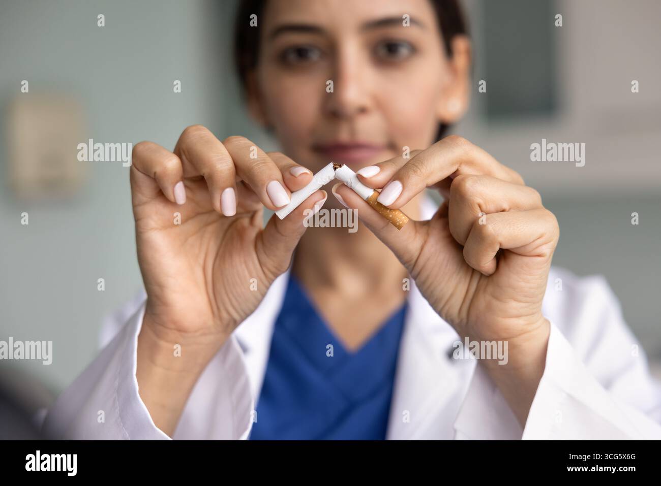 Junge Ärztin bricht Zigaretten aus der Nähe Stockfoto